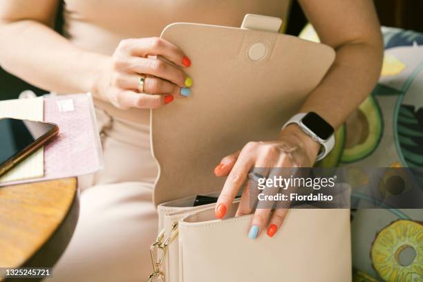 female hands with multi-colored manicure - multi colored purse stock-fotos und bilder
