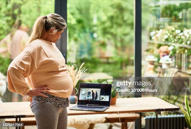 mature pregnant woman receiving guidance from physical therapist online - mentoring virtual stock pictures, royalty-free photos & images