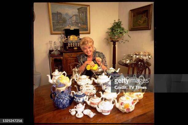 Television presenter Gloria Hunniford photographed at home with her collection of teapots, circa 1995.