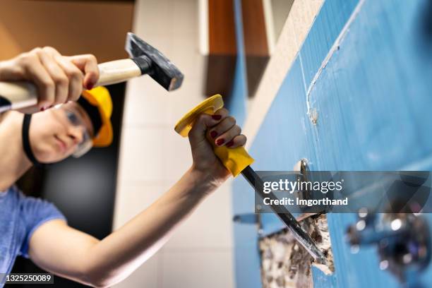 adolescente haciendo un poco de demolición de la casa - renovación - chisel fotografías e imágenes de stock