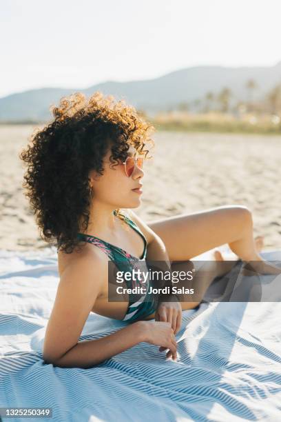 young woman having a sunbath on the beach - beach sunbathing spain fotografías e imágenes de stock