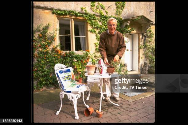 Radio and television presenter Nicholas Parsons repotting a shrub in his garden at home, circa 2000.