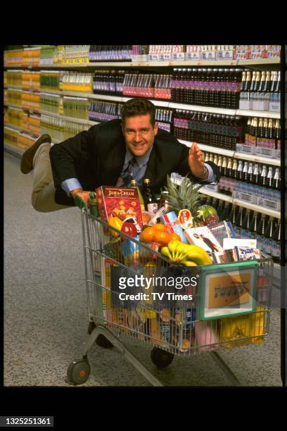 Television presenter Dale Winton posed with a shopping trolley on the set of game show Supermarket Sweep, circa 1993.