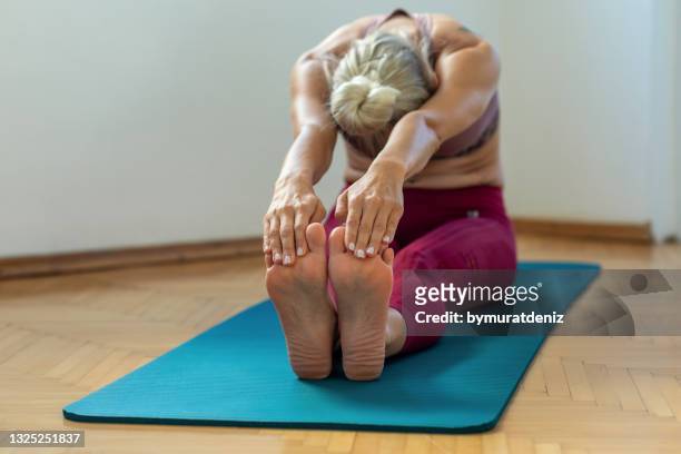 stretching after exercise - female muscle calves stock pictures, royalty-free photos & images