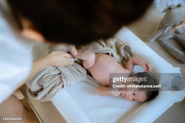 mother cleaning her newborn baby after bathing. - bath sponge stock pictures, royalty-free photos & images