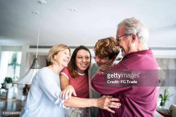 grandparents and grandchildren embracing at home - family unity stock pictures, royalty-free photos & images