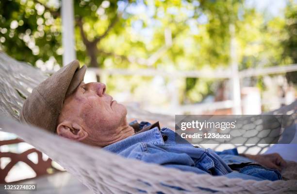 80 plus years senior man relaxation in hammock - man sleeping with cap stock pictures, royalty-free photos & images