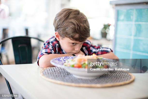 angry child at the table without eating - angry boy stockfoto's en -beelden