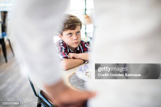 angry child at the table without eating - mépris photos et images de collection