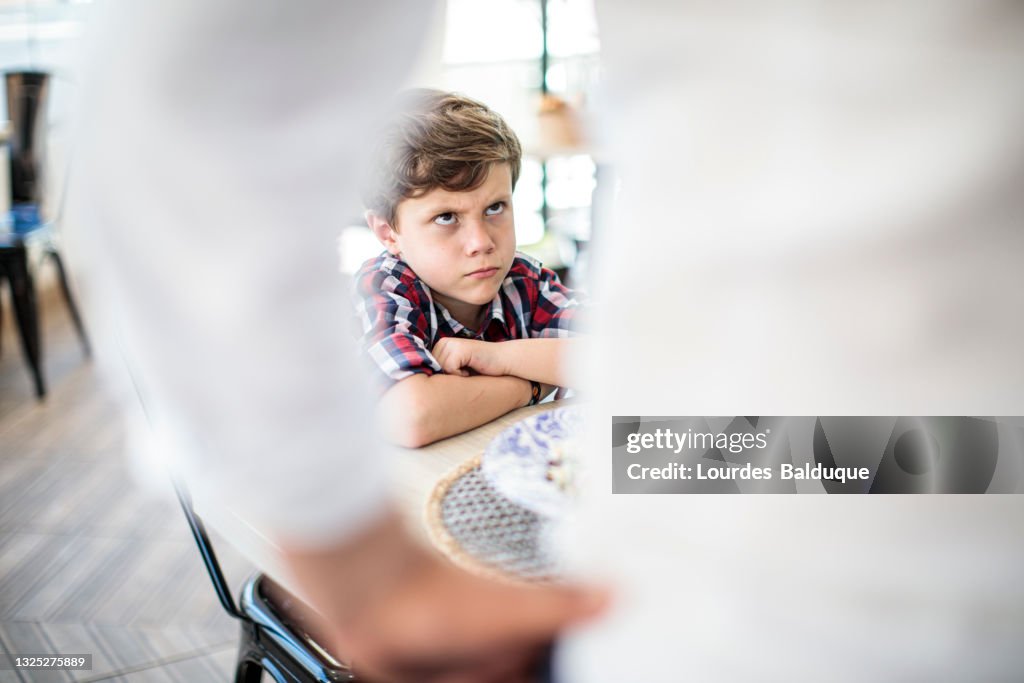 Angry child at the table without eating