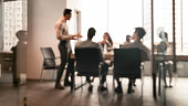 Colleagues having meeting in boardroom, businessman giving speech, blurred photo