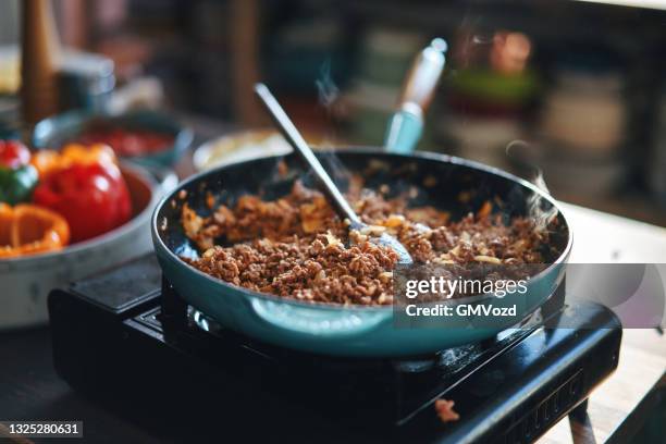preparing stuffed bell peppers with ground meat in tomato sauce - ground beef stock pictures, royalty-free photos & images