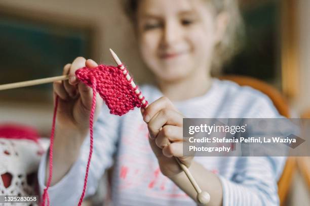 cute little girl learning to knit - girl crocheting stock pictures, royalty-free photos & images