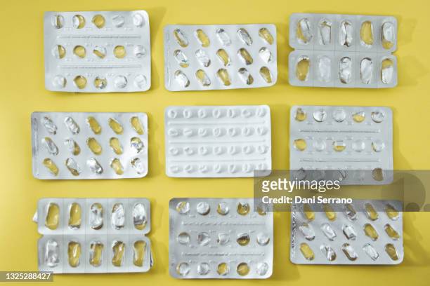 group of empty blisters of drugs over yellow background - blister pack stock-fotos und bilder