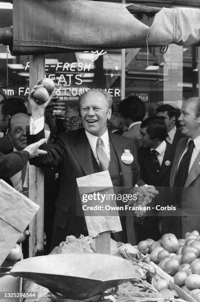 Gerald Ford campaigning for re-election as President in 1976 - tossing fruits to people in a market.