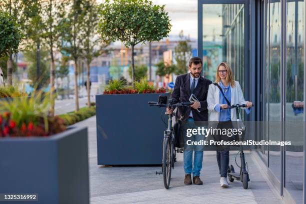smiling business couple outdoors in the street. business communication between young couple. - trotinete imagens e fotografias de stock
