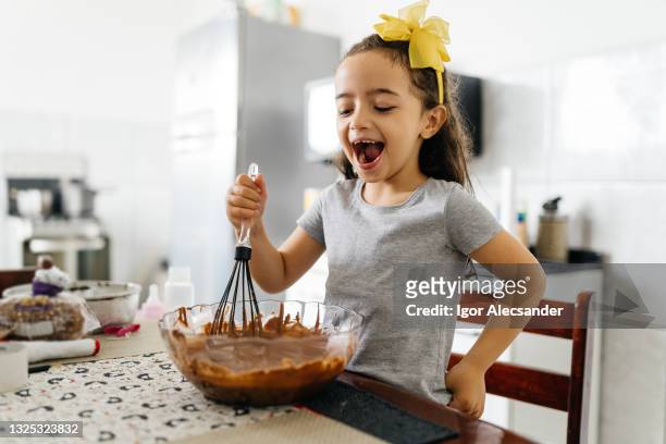 smiling little girl preparing a chocolate pie - chocolate cake stock pictures, royalty-free photos & images