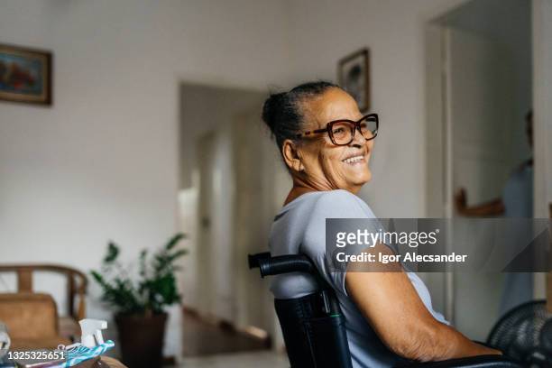 happy elderly woman in the wheelchair - disability stock pictures, royalty-free photos & images