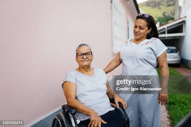 cuidadora de ancianos y mujer en silla de ruedas - plato de acompañamiento fotografías e imágenes de stock