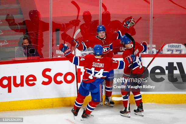 Cole Caufield of the Montreal Canadiens celebrates with Nick Suzuki and Paul Byron after scoring a goal against Robin Lehner of the Vegas Golden...