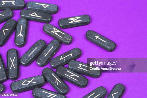 stone runes on bright purple background. concept of magic esoteric rituals. top table view and extreme close-up - rune symbols stock pictures, royalty-free photos & images
