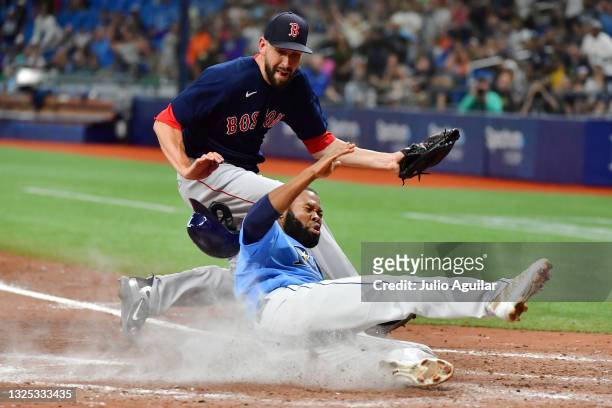 Manuel Margot of the Tampa Bay Rays slides home in the ninth inning after Matt Barnes of the Boston Red Sox threw a wild pitch at Tropicana Field on...