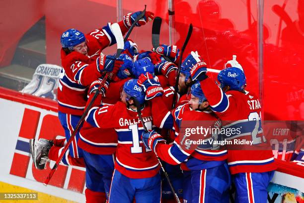 Artturi Lehkonen of the Montreal Canadiens is congratulated by his teammates after scoring the game-winning goal during the first overtime period...