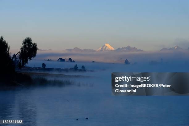 morning fog over the lake laguna piuray, snowy peak of the andes in the back, near chinchero, urubamba province, peru - piuray lake stock pictures, royalty-free photos & images