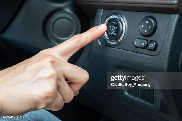 close up of someone trying to ignition car by push start button. - first leg stockfoto's en -beelden