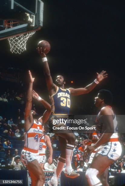 George McGinnis of the Indiana Pacers shoots over Greg Ballard of the Washington Bullets during an NBA basketball game circa 1980 at the Capital...