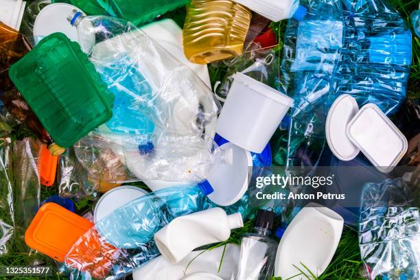 various types of plastic trash on the grass. plastic for recycling. - packaging photos et images de collection