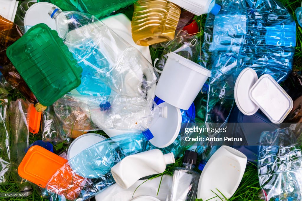 Various types of plastic trash on the grass. Plastic for recycling.