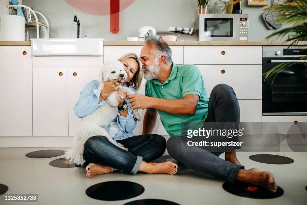 senior man and woman playing with dog - barefoot couples stock pictures, royalty-free photos & images
