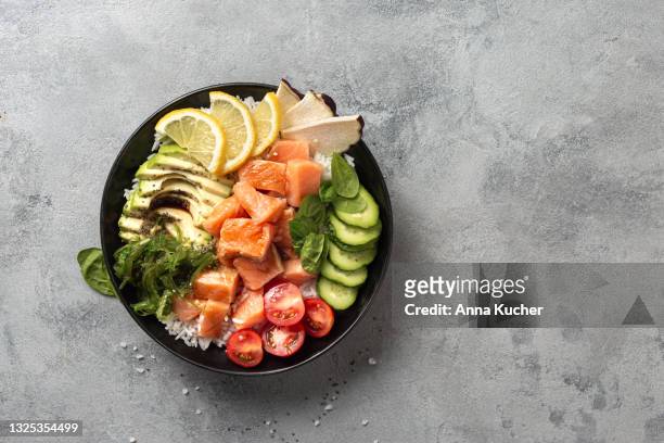 poke bowl with salmon, avocado and vegetables on light background overhead view - salad bowl overhead stock pictures, royalty-free photos & images