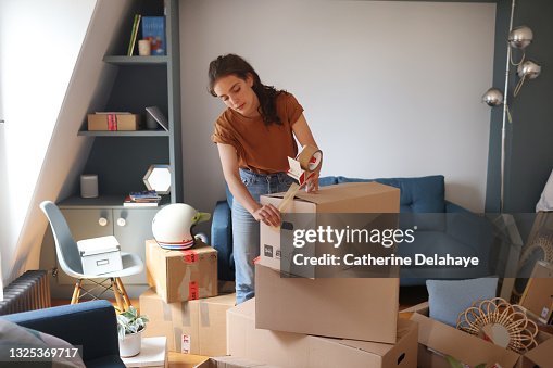 A young woman is packing her moving boxes A young woman is packing her moving boxes