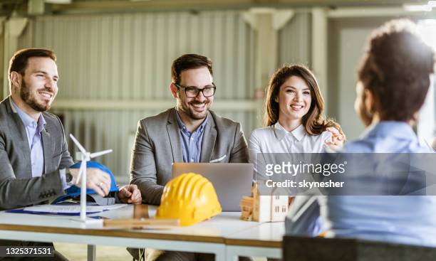 happy architects having a talk during a meeting in the office. - medium group of people stock pictures, royalty-free photos & images