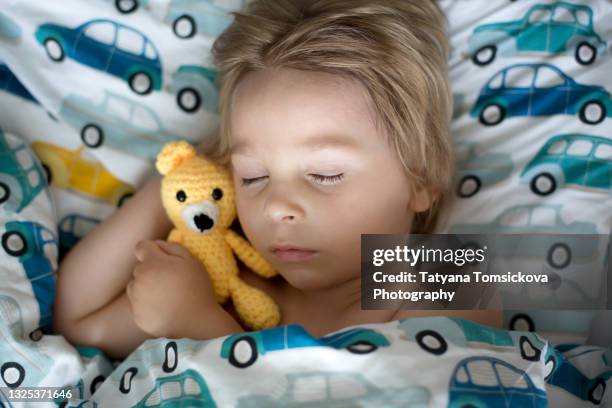 little toddler child, boy, sleeping with little amigurumi toy in the afternoon - bear lying down stock pictures, royalty-free photos & images