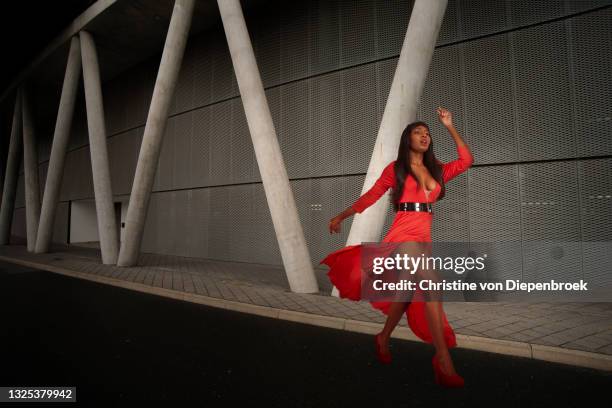 running fashionable woman in red dress - center athlete stock-fotos und bilder