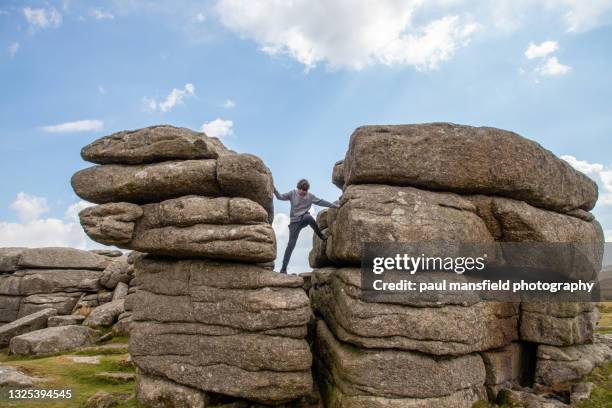 teenage boy on dartmoor rocks - saillie rocheuse photos et images de collection
