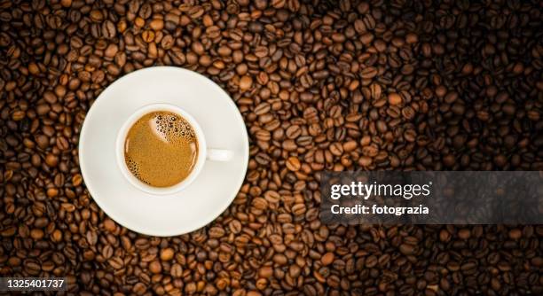 coffee cup on roasted coffee beans background - kaffeepulver stock-fotos und bilder