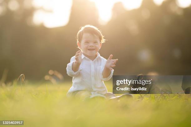 a little boy with down syndrome is smiling - aspergers stock pictures, royalty-free photos & images