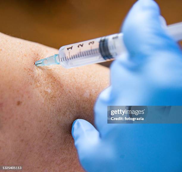 doctor makes vaccination to a senior woman - subcutaneous stock pictures, royalty-free photos & images