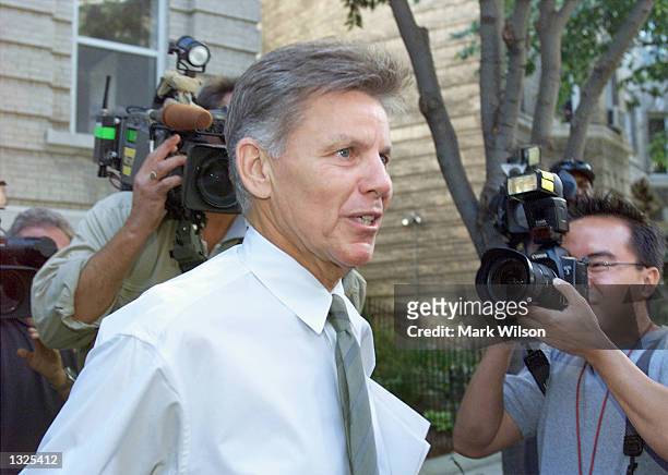 Representative Gary Condit is surrounded by news photographers as he leaves his apartment building July 12, 2001 in Washington, DC.