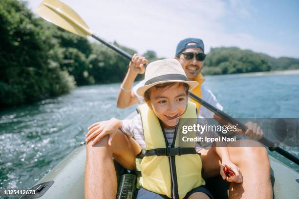 young girl and her father enjoying river kayaking, japan - kayak foto e immagini stock