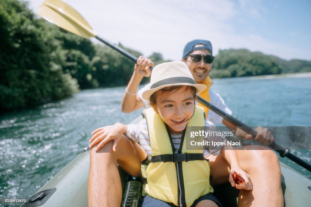 Young girl and her father enjoying river kayaking, Japan