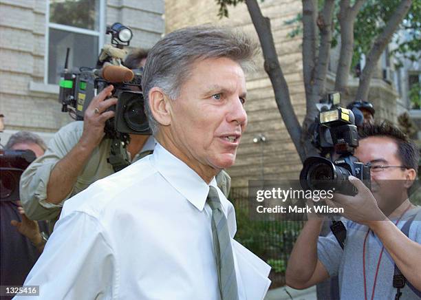 Representative Gary Condit is surrounded by news photographers as he leaves his apartment building July 12, 2001 in Washington, DC. Major daily...