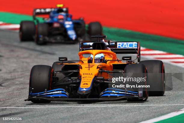 Daniel Ricciardo of Australia driving the McLaren F1 Team MCL35M Mercedes leads Esteban Ocon of France driving the Alpine A521 Renault on track...