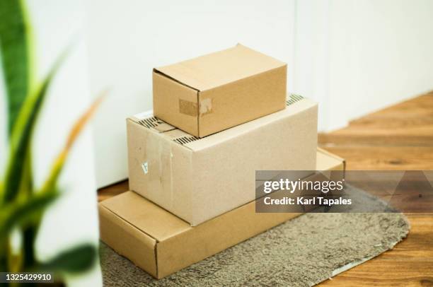 carton boxes delivery on the front door of a residential building - send parcel stock pictures, royalty-free photos & images