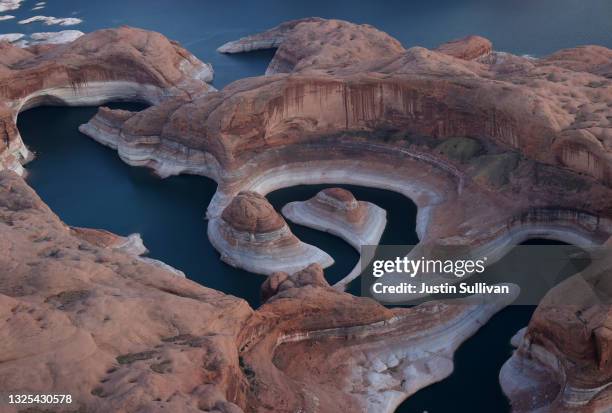 The tall bleached "bathtub ring" is visible on the rocky banks of Lake Powell at Reflection Canyon on June 24, 2021 in Lake Powell, Utah. As severe...