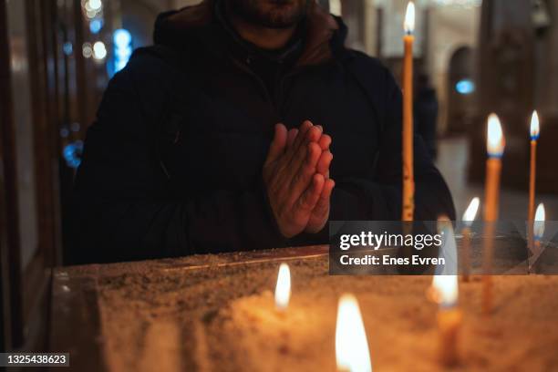 praying at church with candlelight - prayer candle stock pictures, royalty-free photos & images